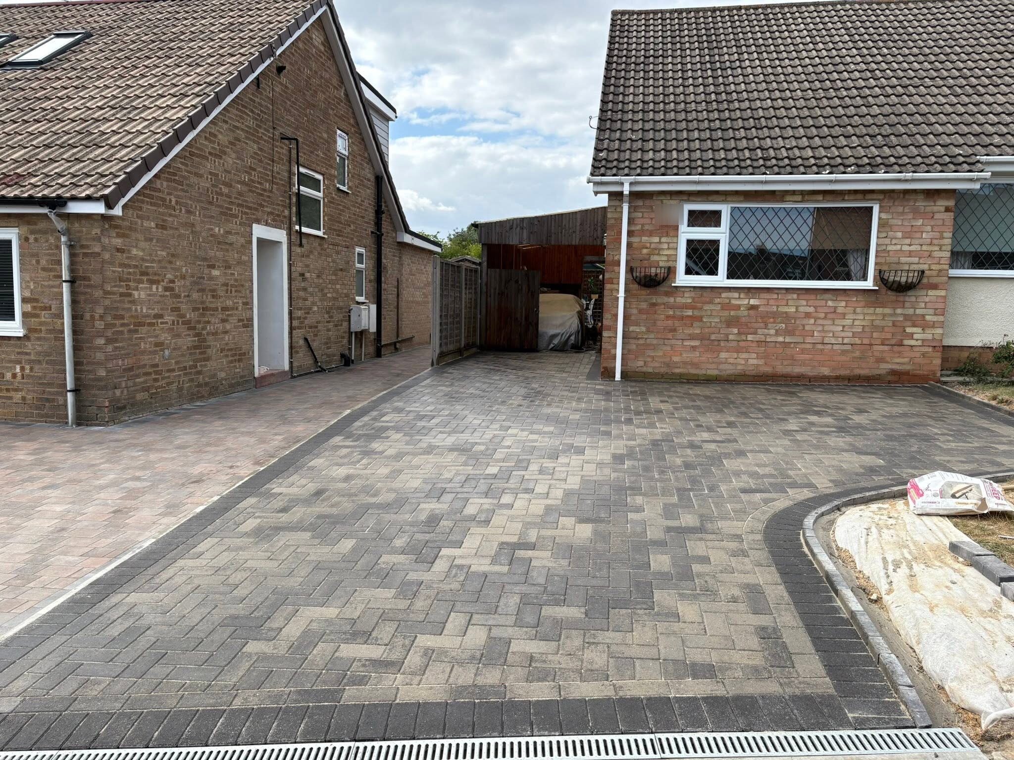 Brett Trio Burnt Oak block paving driveway with charcoal border running between two bungalows in Burham, Medway