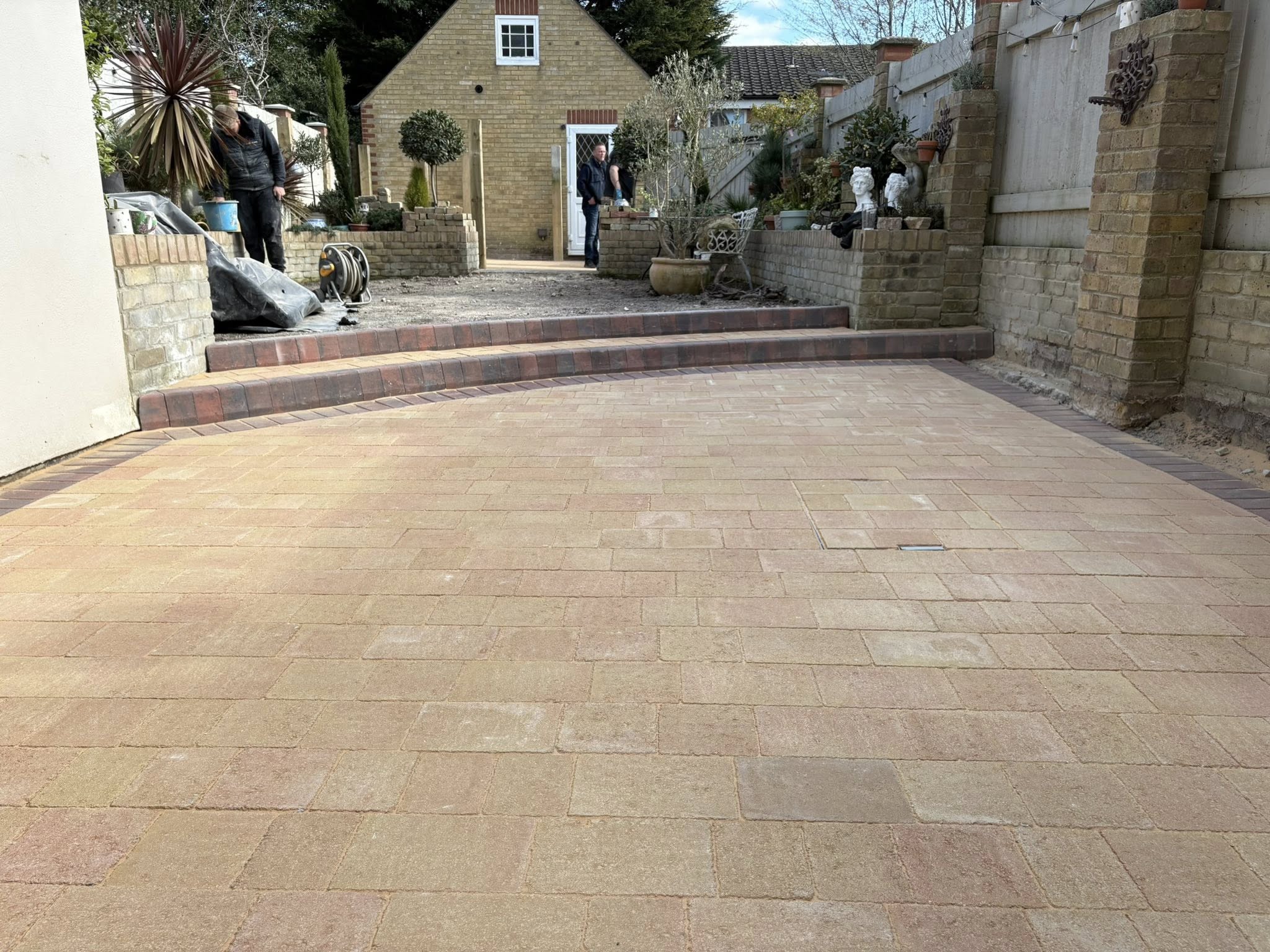 Finished mellow yellow block paving garden with brindle key kerb steps and view to cottage in Canterbury