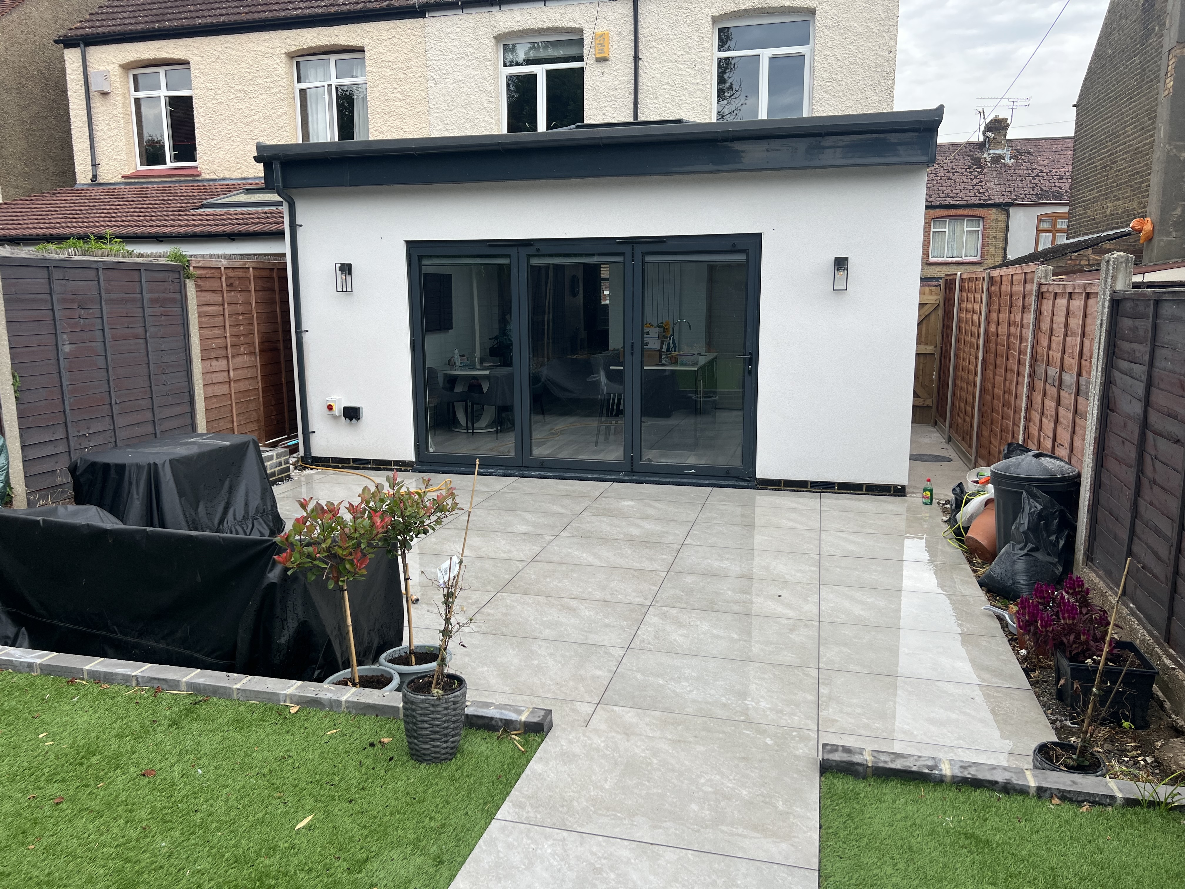 Completed open plan rear extension with bifold doors and white render Medway