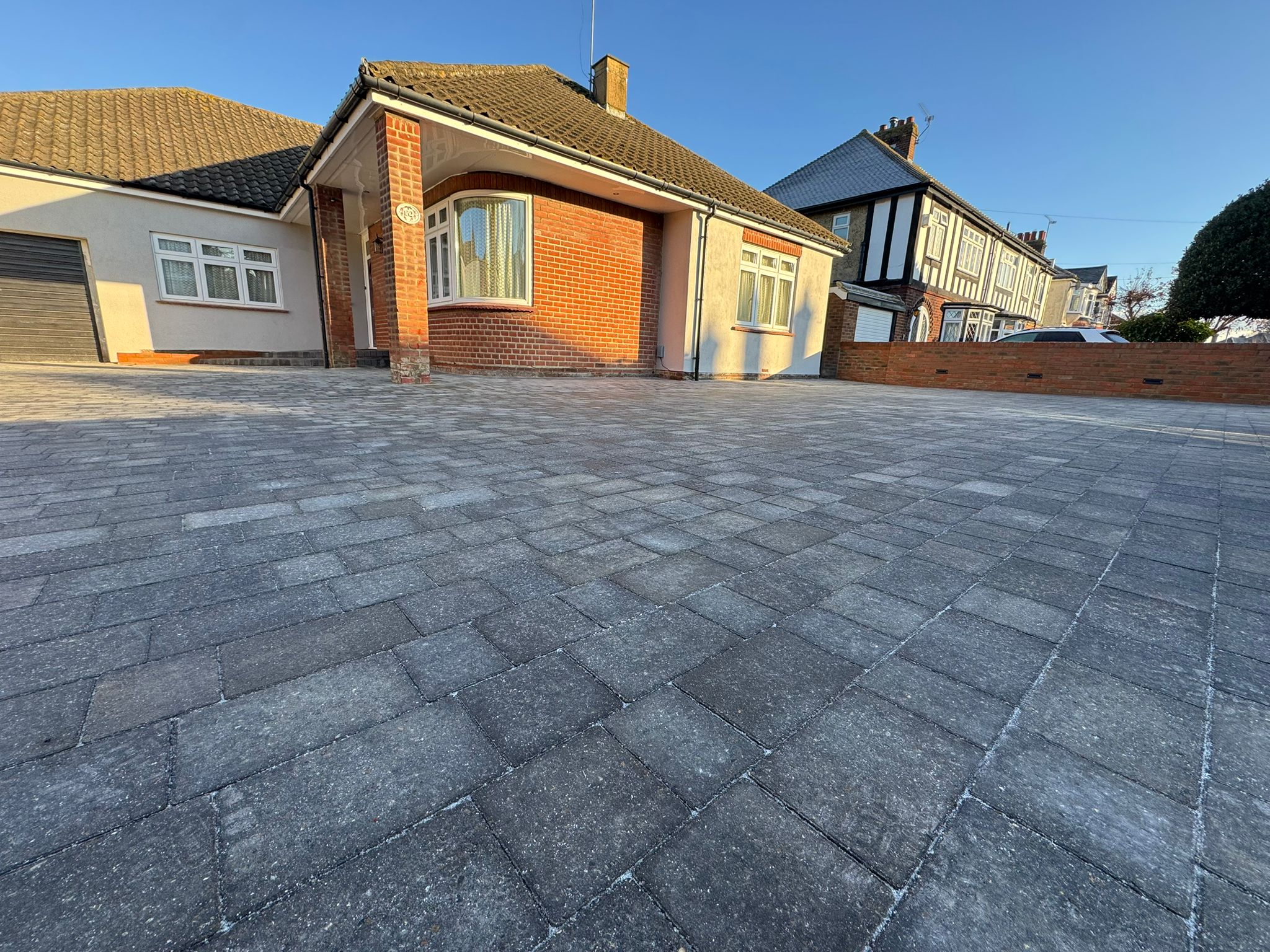 Detailed view of grey block paving driveway with brick walls and integrated lighting Rochester