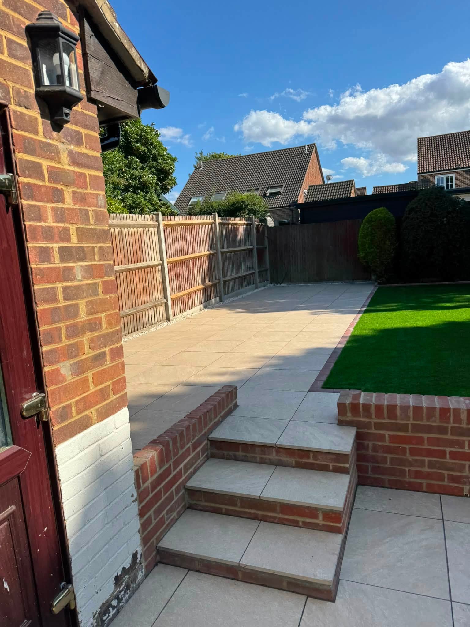 Brick steps with Aura Beige porcelain treads between the patio and raised lawn in Hempstead, Gillingham