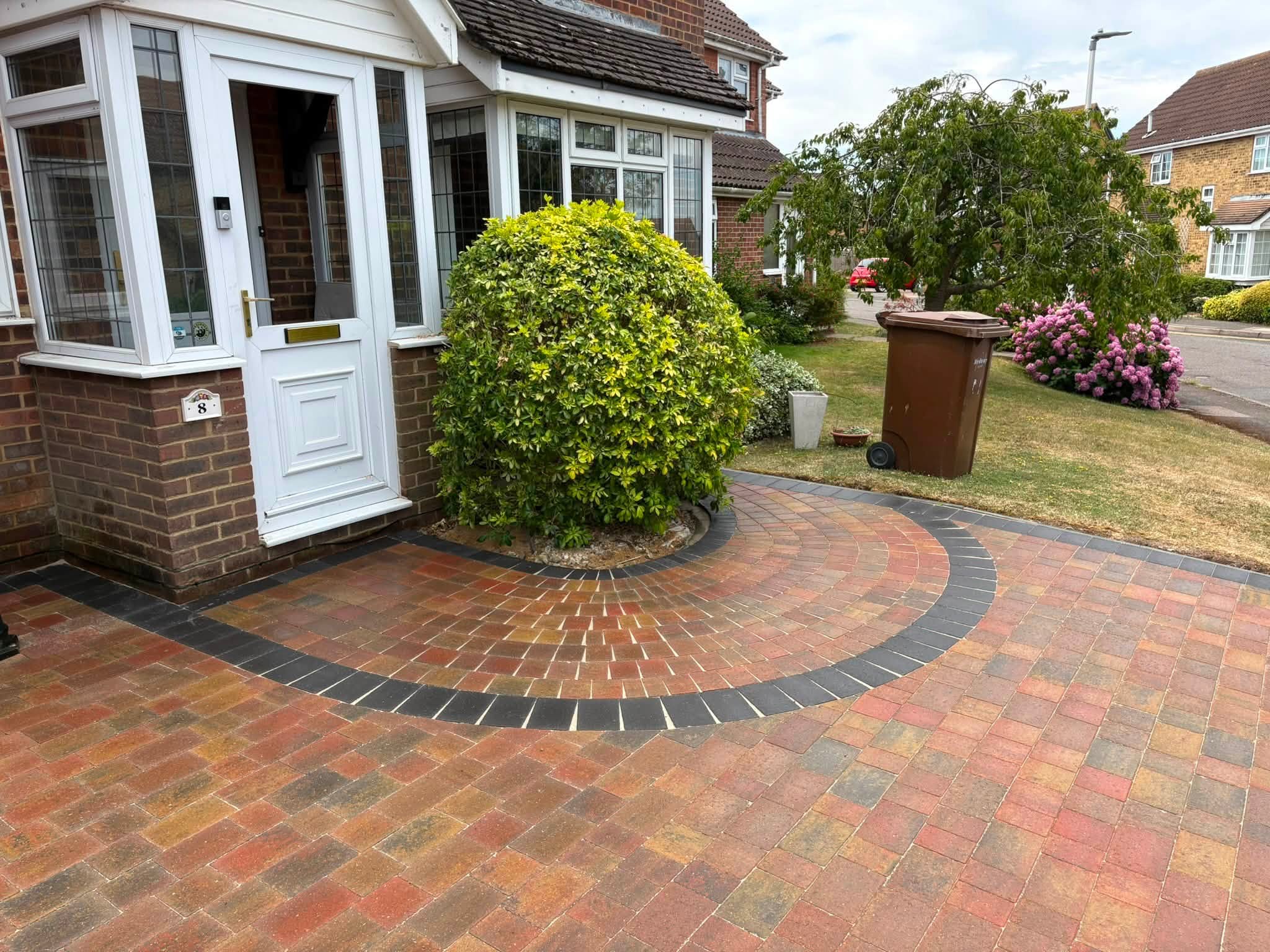 Curved charcoal block border beside the front entrance of a Lordswood driveway
