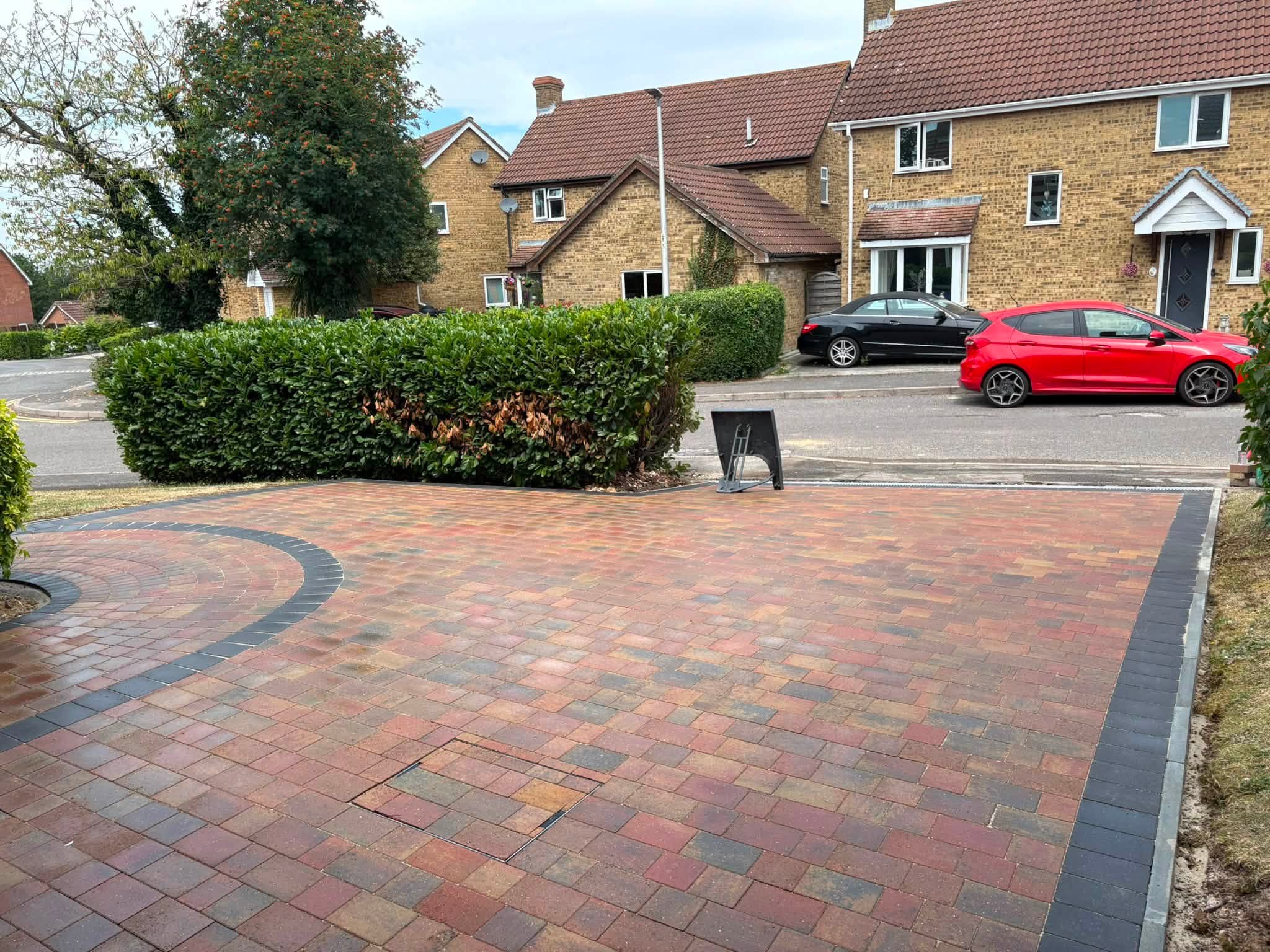 Road view of an Autumn Gold block paved driveway with charcoal edging in Lordswood