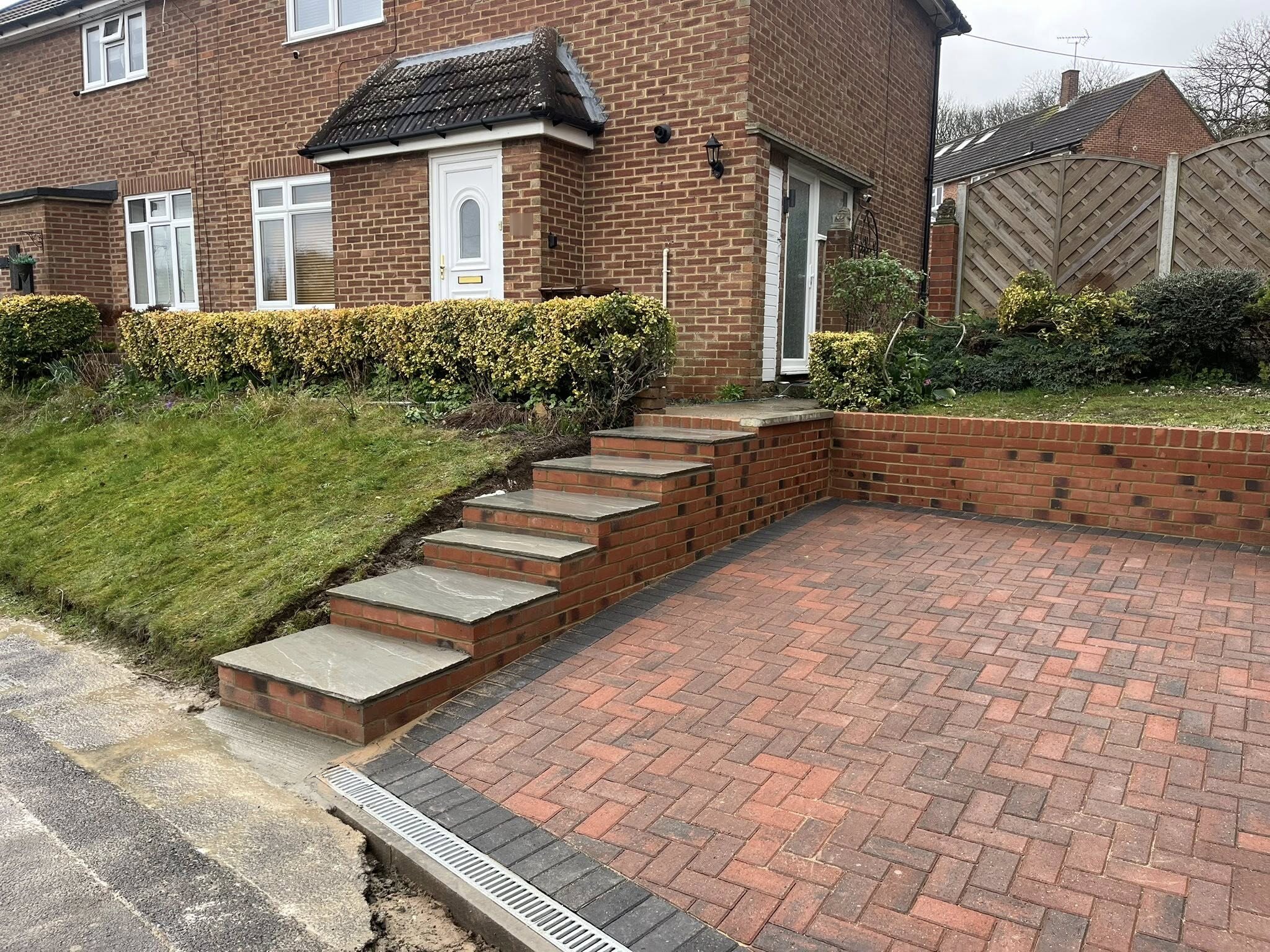 Completed Brett omega block paving driveway with charcoal border and sandstone steps in Maidstone