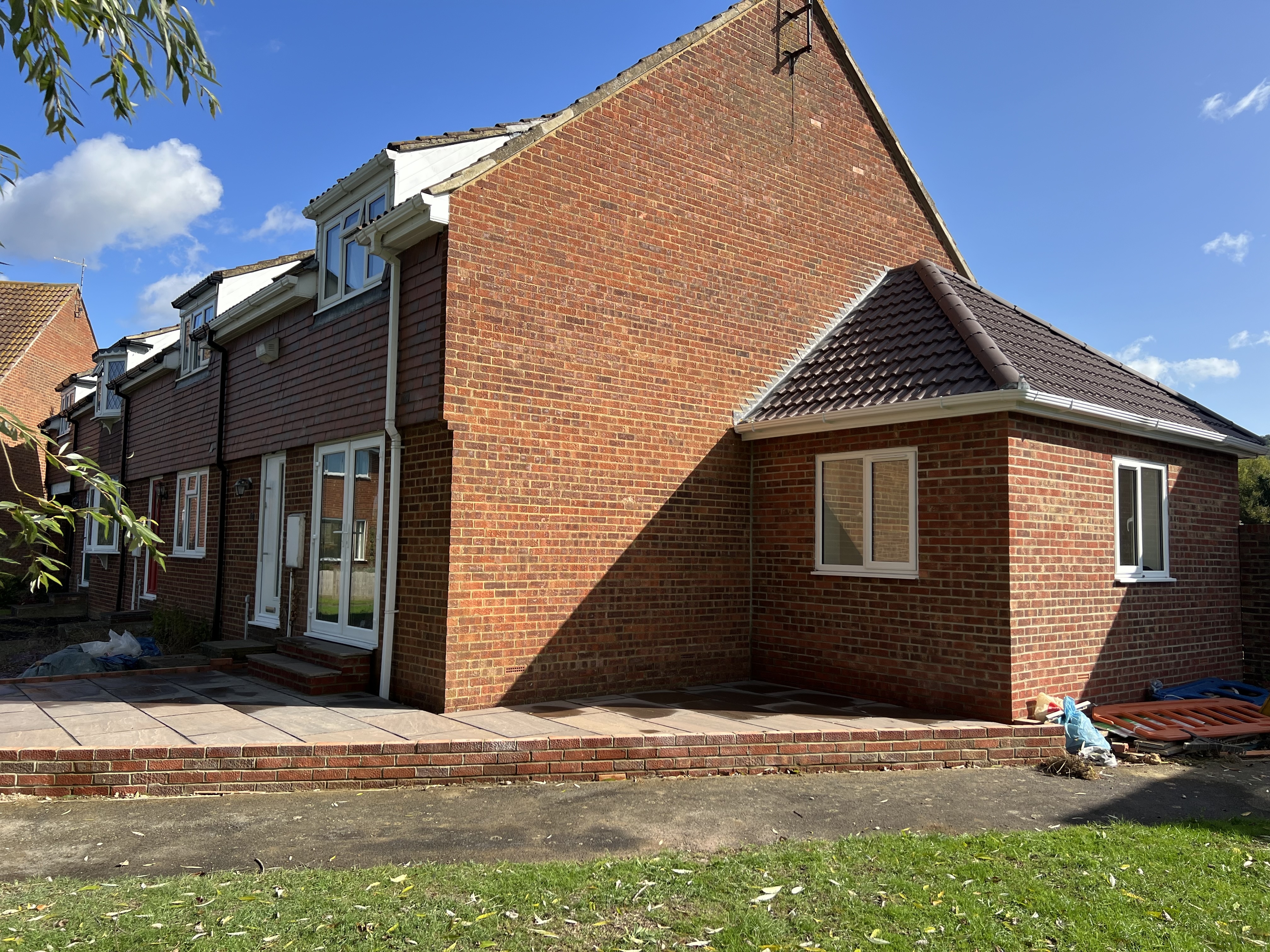 Completed red brick side extension in Bexley with tiled pitched roof and brick-bordered patio