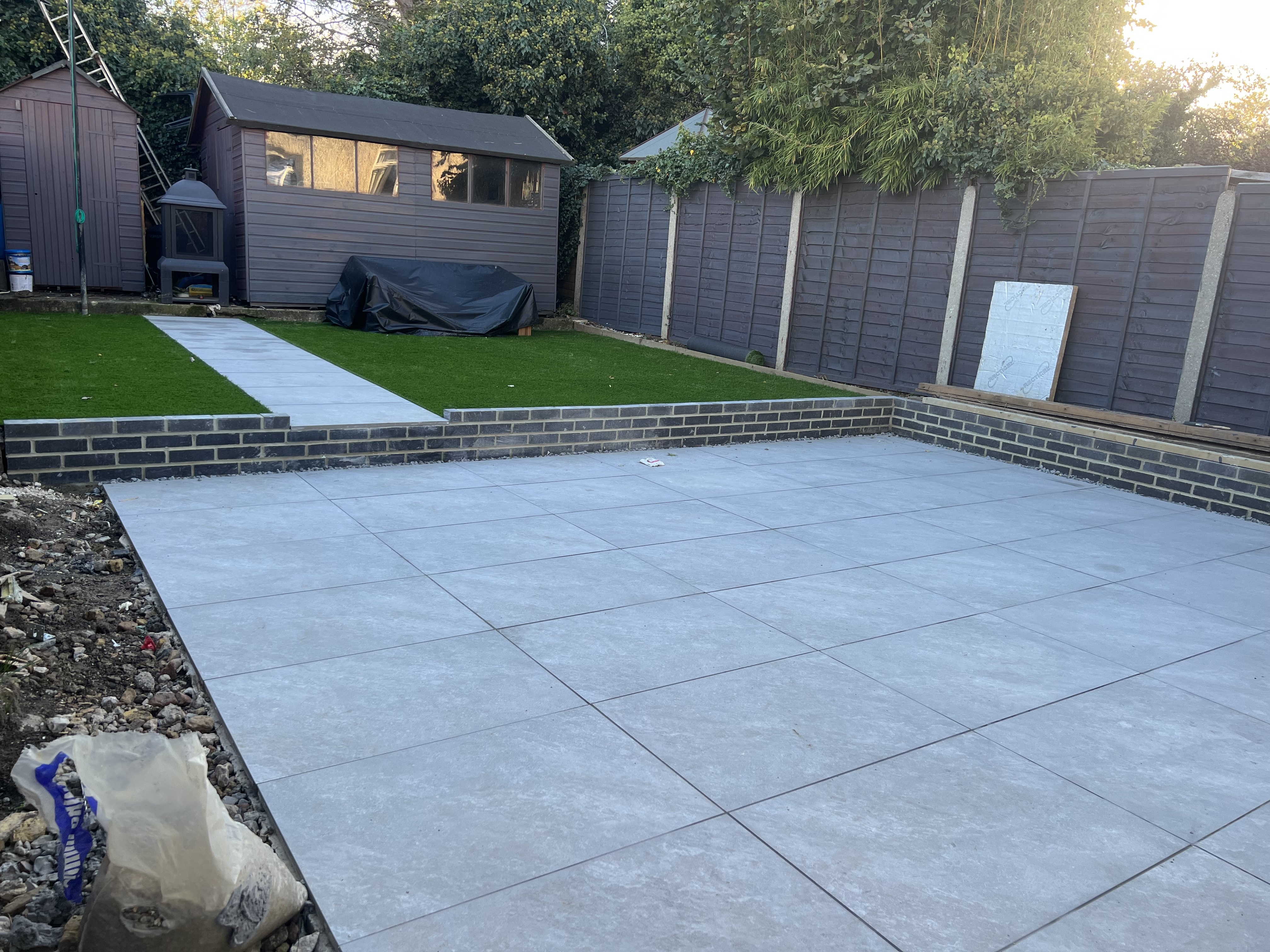Light grey paving patio with artificial lawn after extension Medway